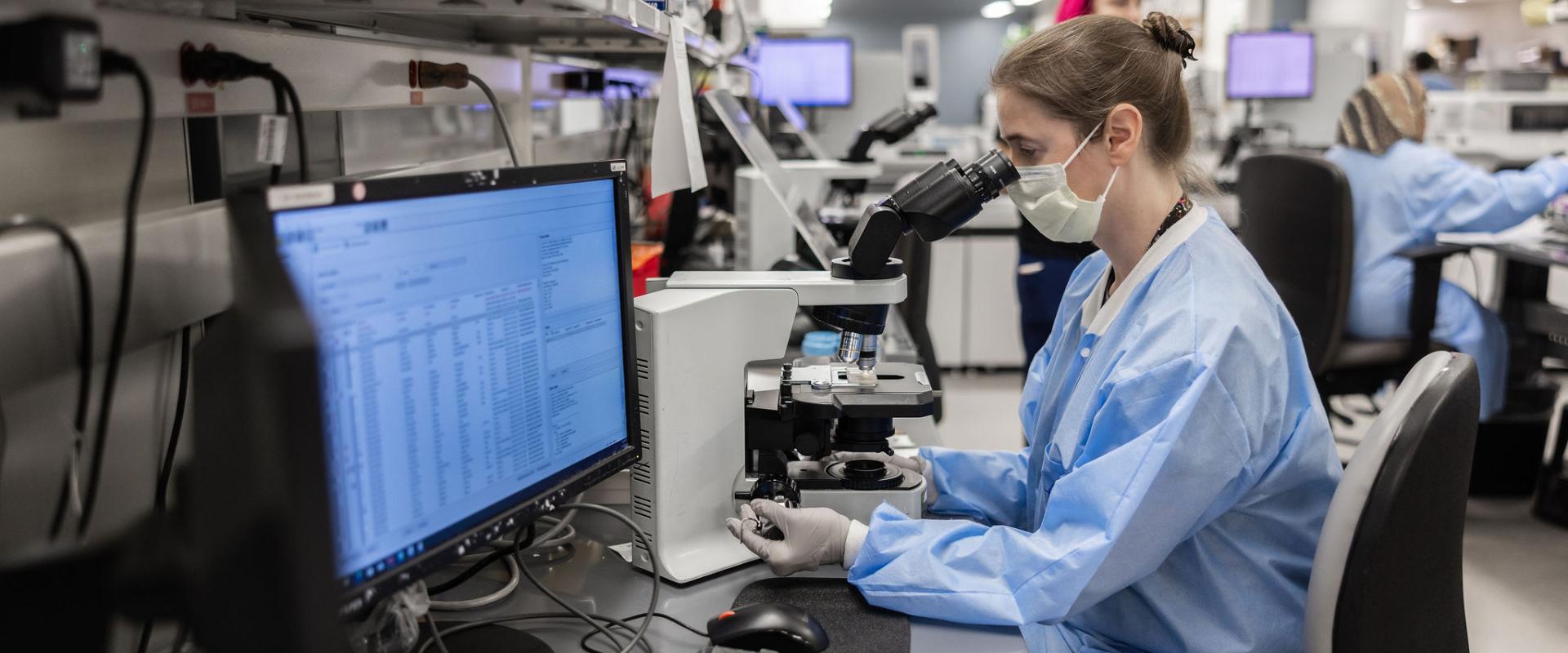 Doctor looking at cells under a microscope