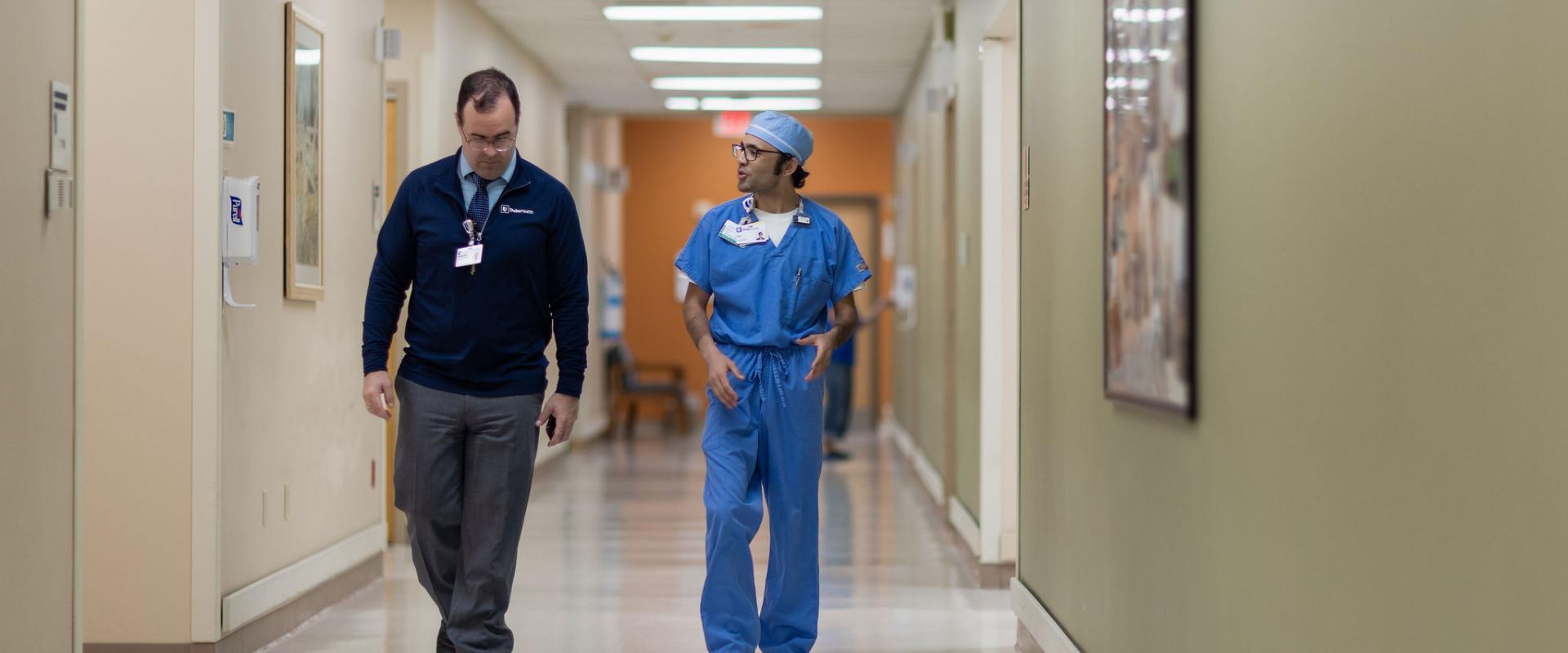 Doctor and hospital administrator walking in hall 